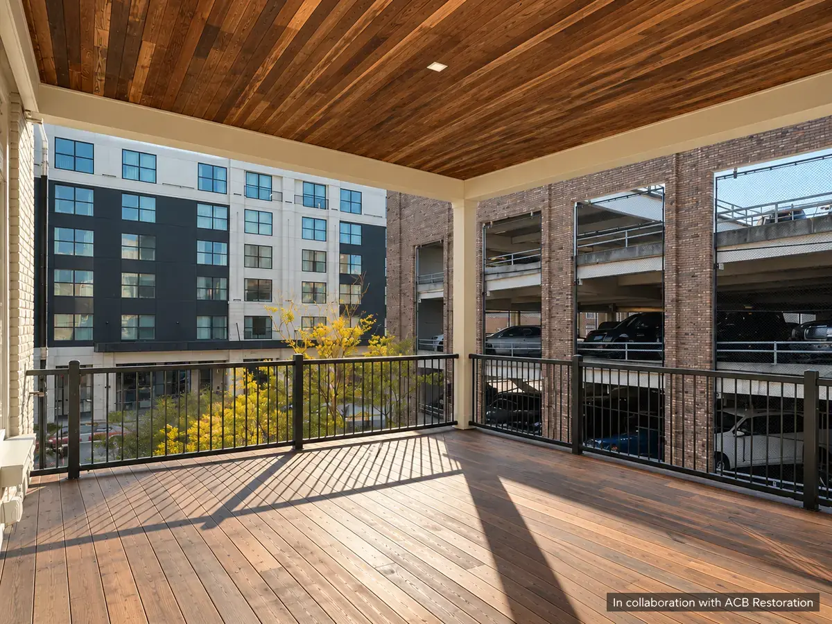 Covered terrace with wood decking, a finished timber ceiling and metal railing. In collaboration with ACB Restoration.